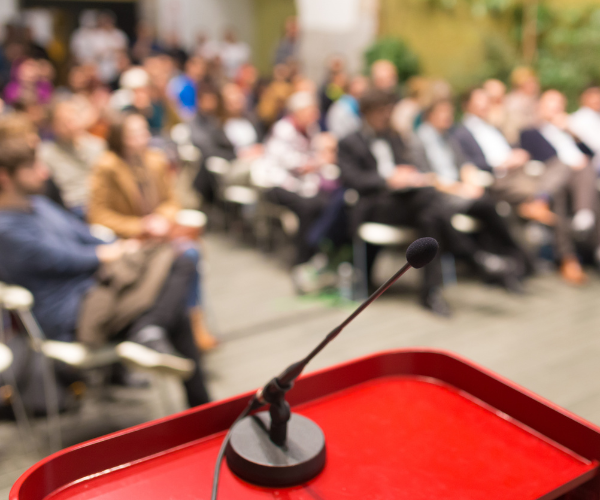 public à table ronde avec microphone en premier plan